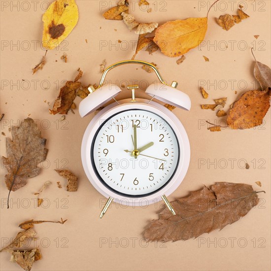 Alarm clock with autumn foliage, end of daylight saving time in fall, winter time changeover