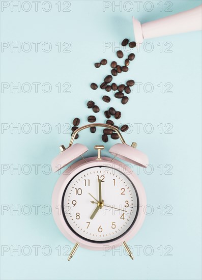 Wake up in the morning, time for breakfast, coffee break, alarm clock with roasted beans pouring