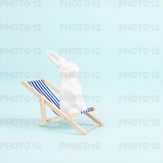 Bunny or rabbit sitting on lounge chair, easter holiday, vacation by the sea