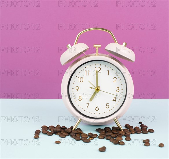 Alarm clock with roasted coffee beans, wake up in the morning, time to stand up, hot drink for