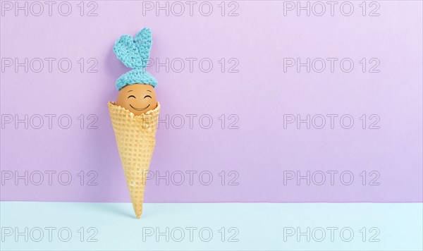 Cute easter bunny or rabbit with a smiling egg face in an ice cream cone, spring holiday, greeting