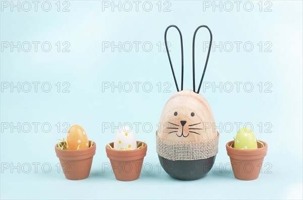 Cute easter bunny, baby rabbit with eggs in a flower pot, spring holiday greeting card