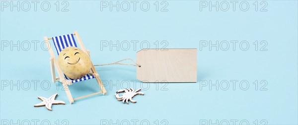 Potato with a funny smiling face is sitting in lounge chairs, blank sign, happy vacation greeting