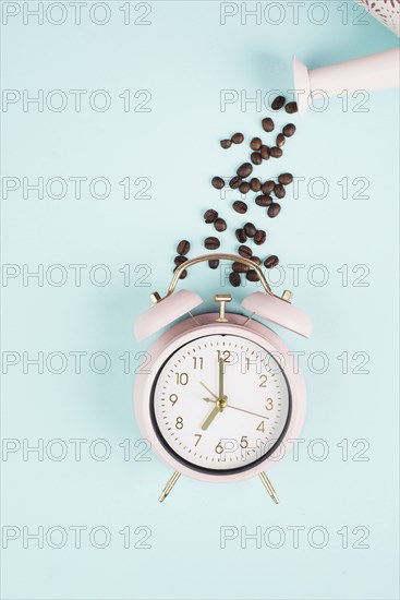 Wake up in the morning, time for breakfast, coffee break, alarm clock with roasted beans pouring