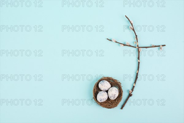 Religious cross made from willow branches, easter nest with eggs, belief, faith and spirituality in