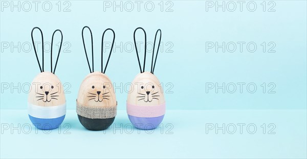 Easter bunny or rabbit group, holiday background and greeting card, painted wooden egg