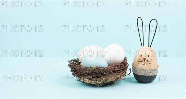 Easter bunny or rabbit group with wicker basket, willow branches, wooden egg, spring holiday