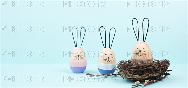 Easter bunny or rabbit group with wicker basket, willow branches, wooden egg, spring holiday