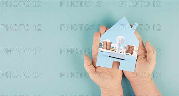 Holding a house in the hand with Euro banknotes and a stamp, new law for property tax in Germany