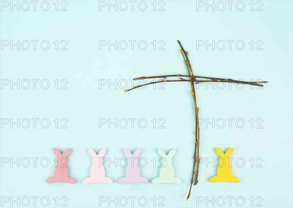 Easter bunny or rabbit with a religious cross made from willow branches, christian spring holiday,