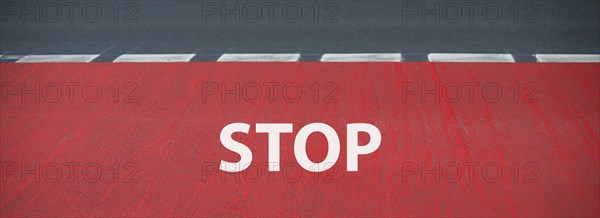 Stop is standing on the road, warning sign, take caution, finish line for a runner on the asphalt,