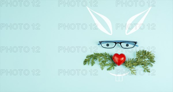 Easter rabbit face with a heart shaped nose, whiskers from carrot leaves and eyeglasse, holiday