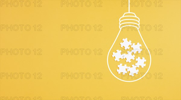 Light bulb with jigsaw or puzzle pieces, brainstorming for ideas, finding solution, solving a