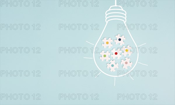 Light bulb with jigsaw or puzzle pieces, brainstorming for ideas, finding solution, solving a