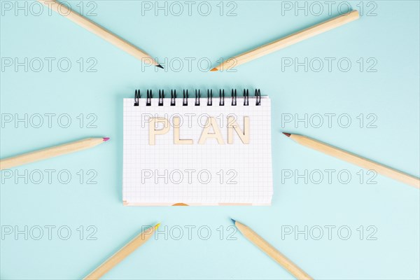 Plan is standing in a notebook, planning new goals, to do list, colorful pencils, new year