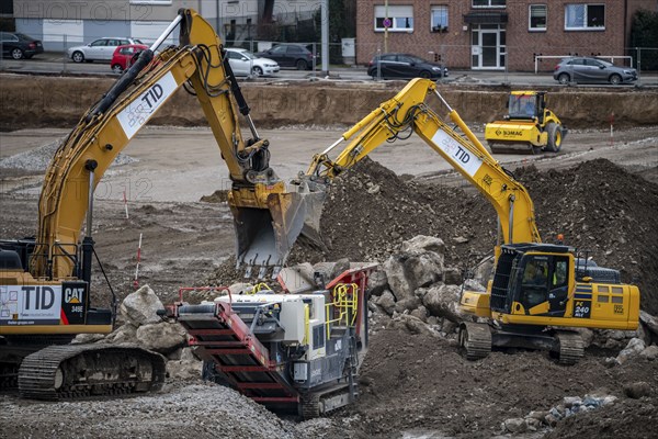 Construction site, processing of a building site, shredding of building rubble, excavators fill
