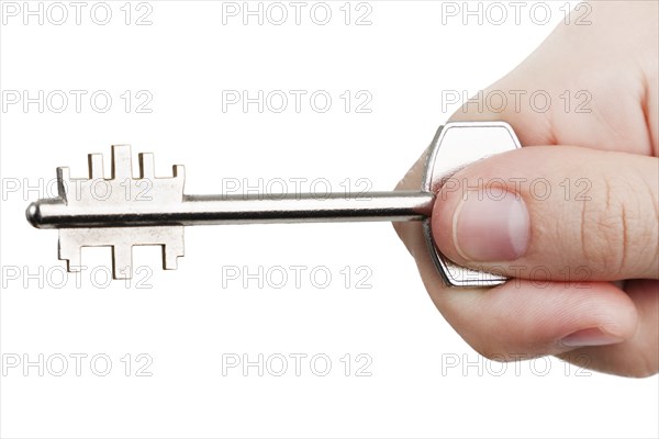 Human hand holding steel metal house door lock key