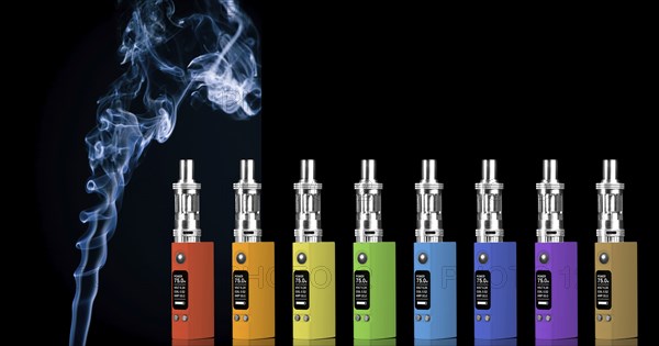 Eight multicolored electronic cigarettes and smoke, isolated on black background