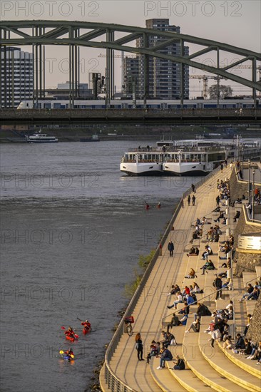 Rhine promenade, Rhine boulevard, on the Deutz bank, people sitting in the spring sun on the Rhine,