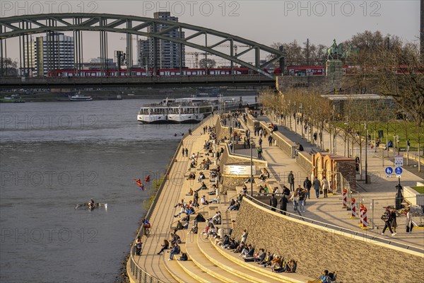 Rhine promenade, Rhine boulevard, on the Deutz bank, people sitting in the spring sun on the Rhine,
