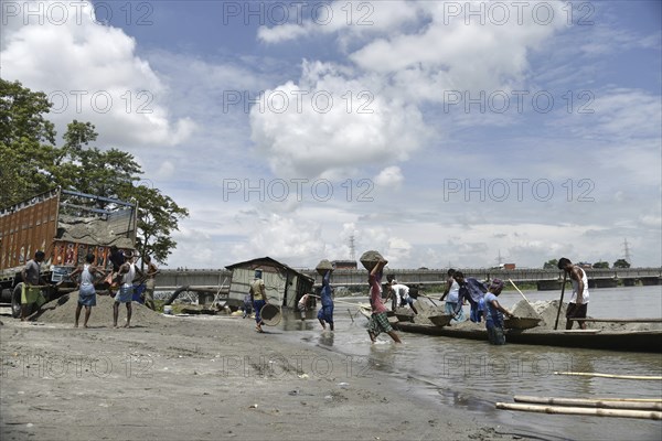 Labourer carries extracted sand from Beki River, in Barpeta district in Assam, India on Sunday