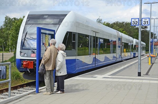 Two people look at the tour list at the local trains that serving Stralsund in Germany and