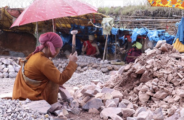 Khasi women breaking stones into different sizes by hammer, in a village in Meghalaya, India on 20