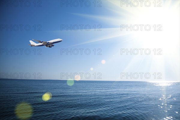 Airplane flying over the sea. Vacations concept