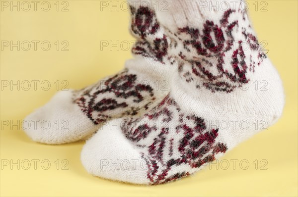 Children's feet in wool socks on a yellow background