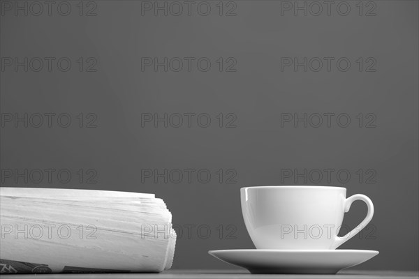 White mug and newspaper on a gray background