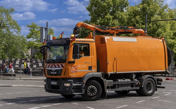 Operational vehicle of the Berlin city cleaning service with German flags on the driver's cab,