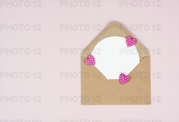 Valentine day greeting card, envelope with hearts on pastel background, love symbol, flat lay