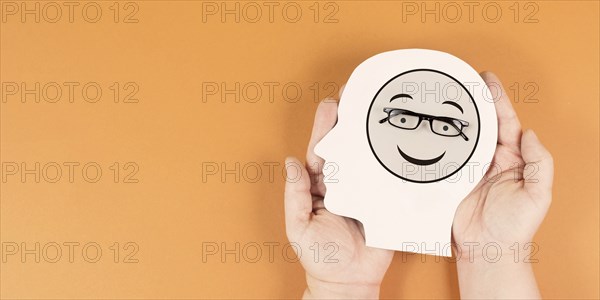 Holding a head with a happy smiling face, mental health concept, positive mindset, support and
