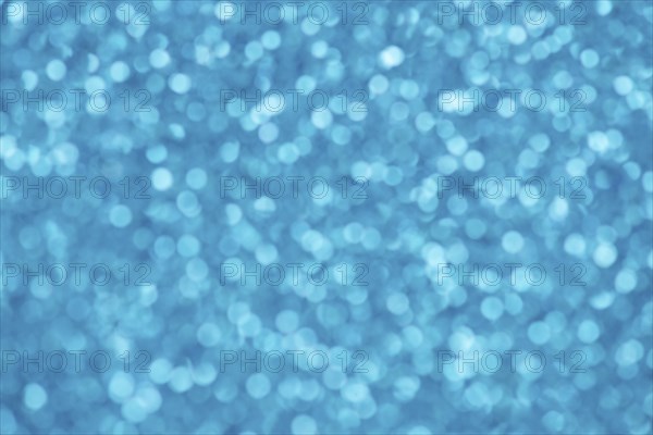 Blue bokeh background for christmas, defocused round lights and sunbeams, flare overlay