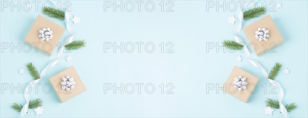 Christmas holiday greeting card with little gift boxes, stars and fir branches, blue background