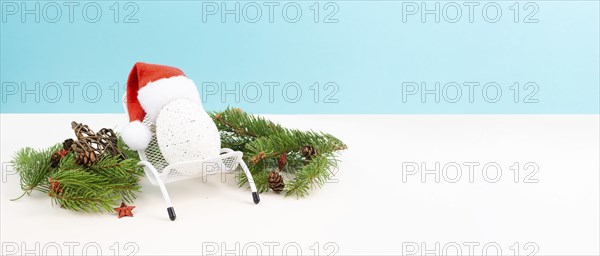 Santa Claus with a red hat sitting in a lounge chair, holiday by the sea, taking a vacation,