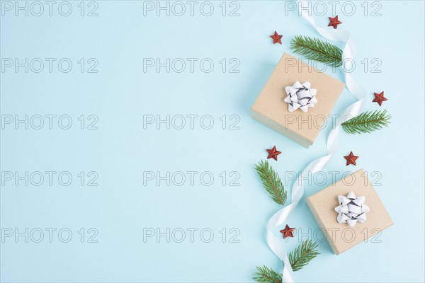 Christmas holiday greeting card with little gift boxes, stars and fir branches, blue background