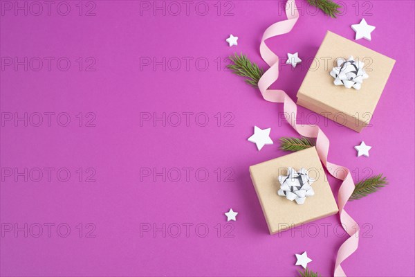 Christmas holiday background with little gift boxes, stars and fir branches, pink trendy background