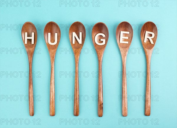 Hungry is standing in german language on the wooden spoons, food shortage and starving because of