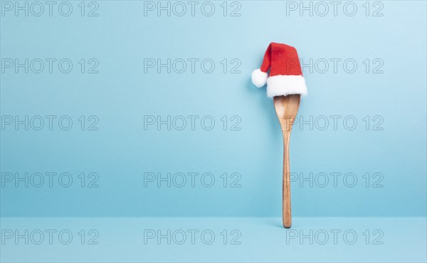Blank paper with a wooden spoon and a red Santa Claus hat, christmas greeting card, copy space for