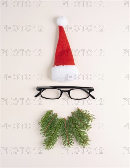 Christmas season, Santa Claus face with a red hat, eyeglasses, beard made from fir twigs,
