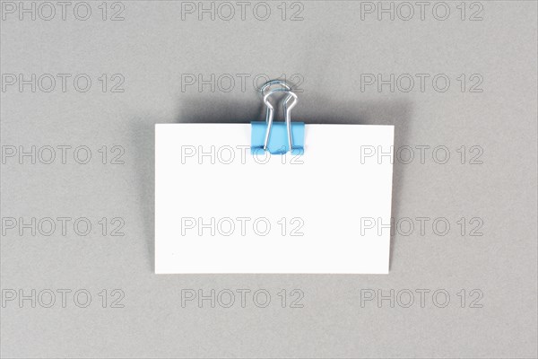 Blank white paper with a paperclip on a graycolored background, copy space for text, reminder or