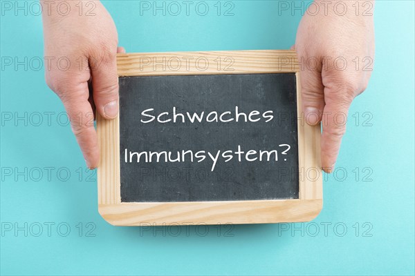 Weak immune system is standing in german language on a chalkboard, healthy eating and lifestyle