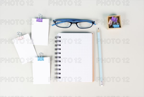 Blank notebook with a pen, paper and eyeglasses on a gray background, brainstorming for ideas,