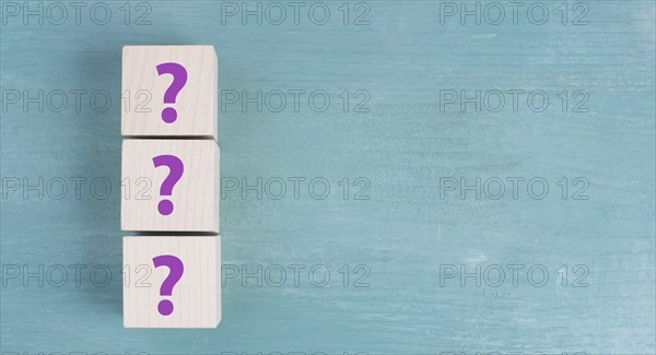 Three wooden cubes with question marks in purple color, searching for an answer, customer service