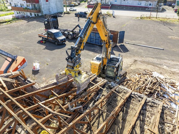 Aerial view of a construction site where an excavator is moving scrap and building material,