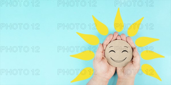 Holding a smiling face with yellow petals in the hands, mental health concept, positive mindset,