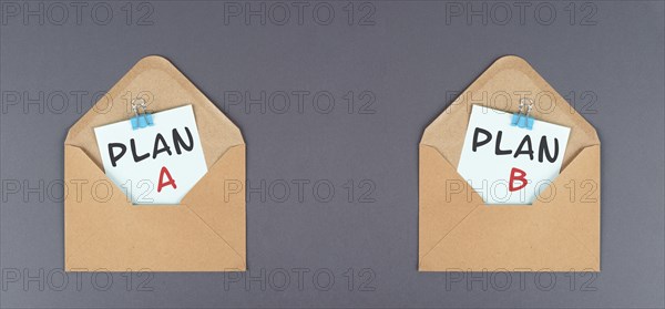 Plan A and B standing on paper, brainstorming for possibilities, making a decision