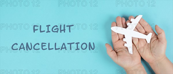 Holding an airplane in the hands, flight cancellation is standing on the paper, staff shortage at