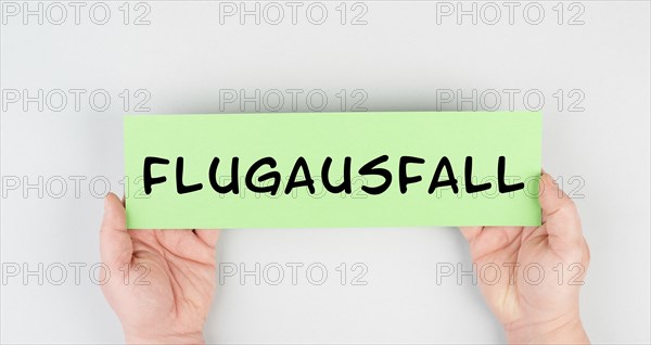 The word flight cancellation is standing in german language on the paper, staff shortage at the